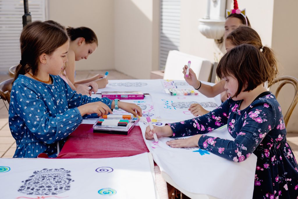 girls at birthday party decorating pillow covers